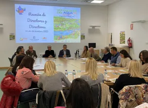 Personas reunidas en torno a una mesa con una presentación