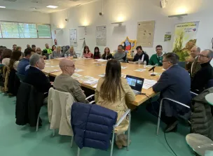 Personas reunidas en torno a una mesa con una presentación