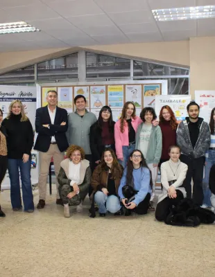 Grupo de estudiantes, Delegado de Educación y personal de la administración docentes posando juntos en un centro educativo durante una exposición de 