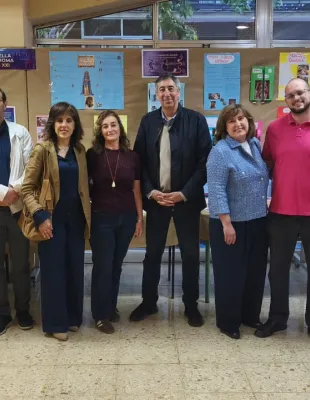 Grupo de unas doce personas adultas posando en el interior de un centro educativo. En la imagen aparece el delegado de Educación, Cultura y Deportes 