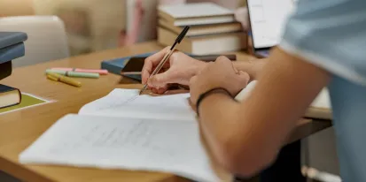 Alumno que escribe sobre una hoja de examen